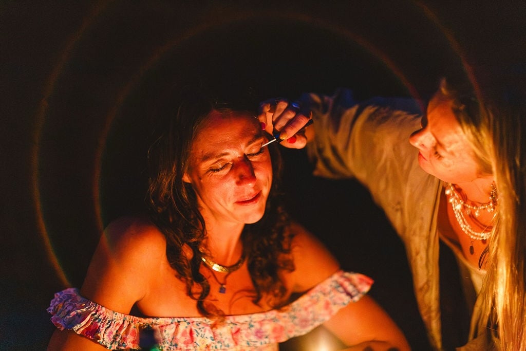 Face paint being applied by firelight