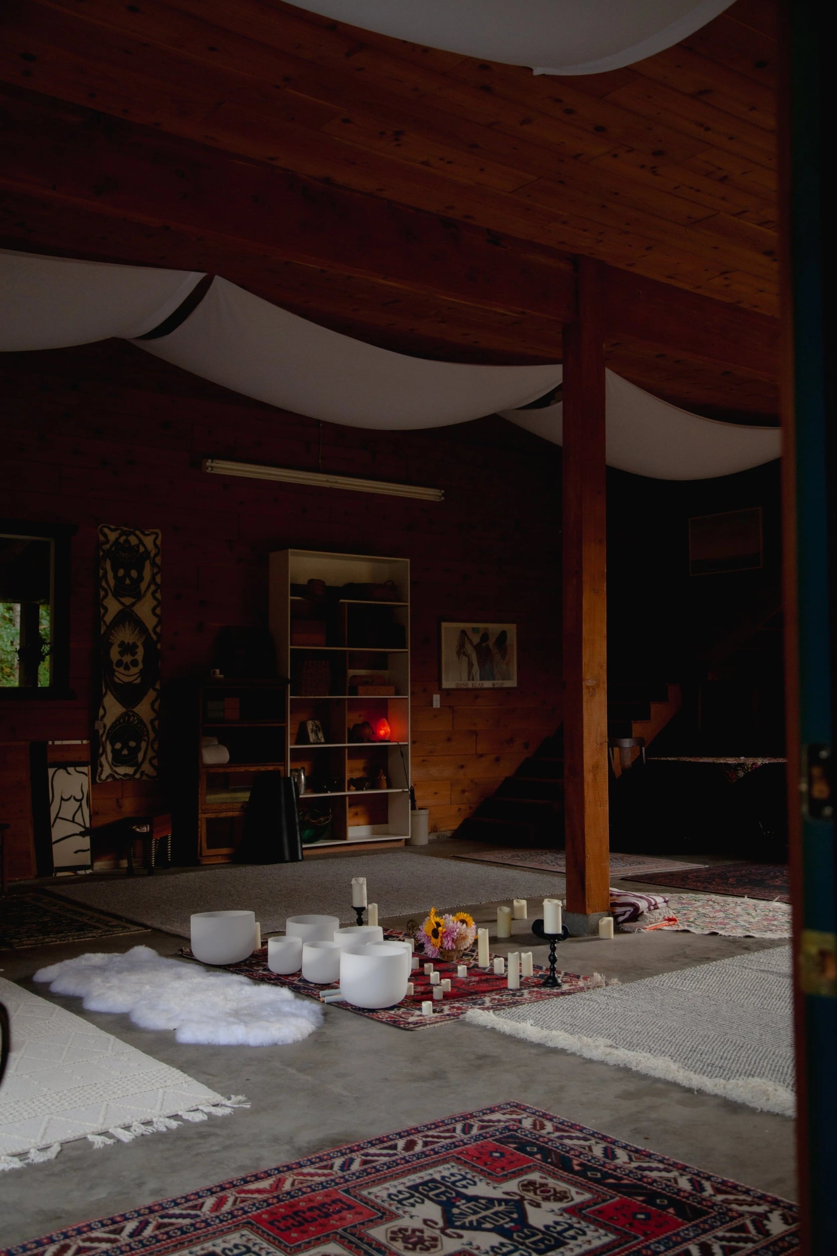 Candles and rugs on the barn floor under draped fabric