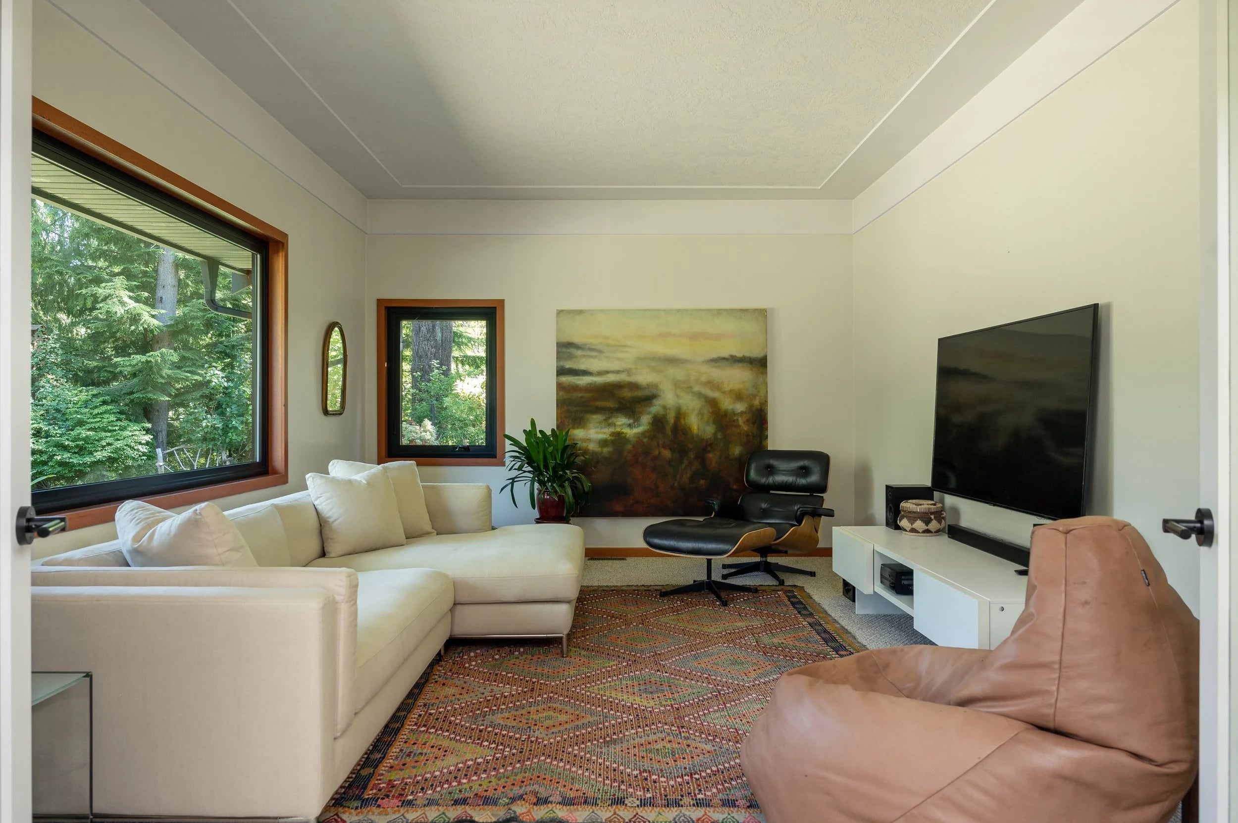 A cream sofa and a painting in a bright sitting room