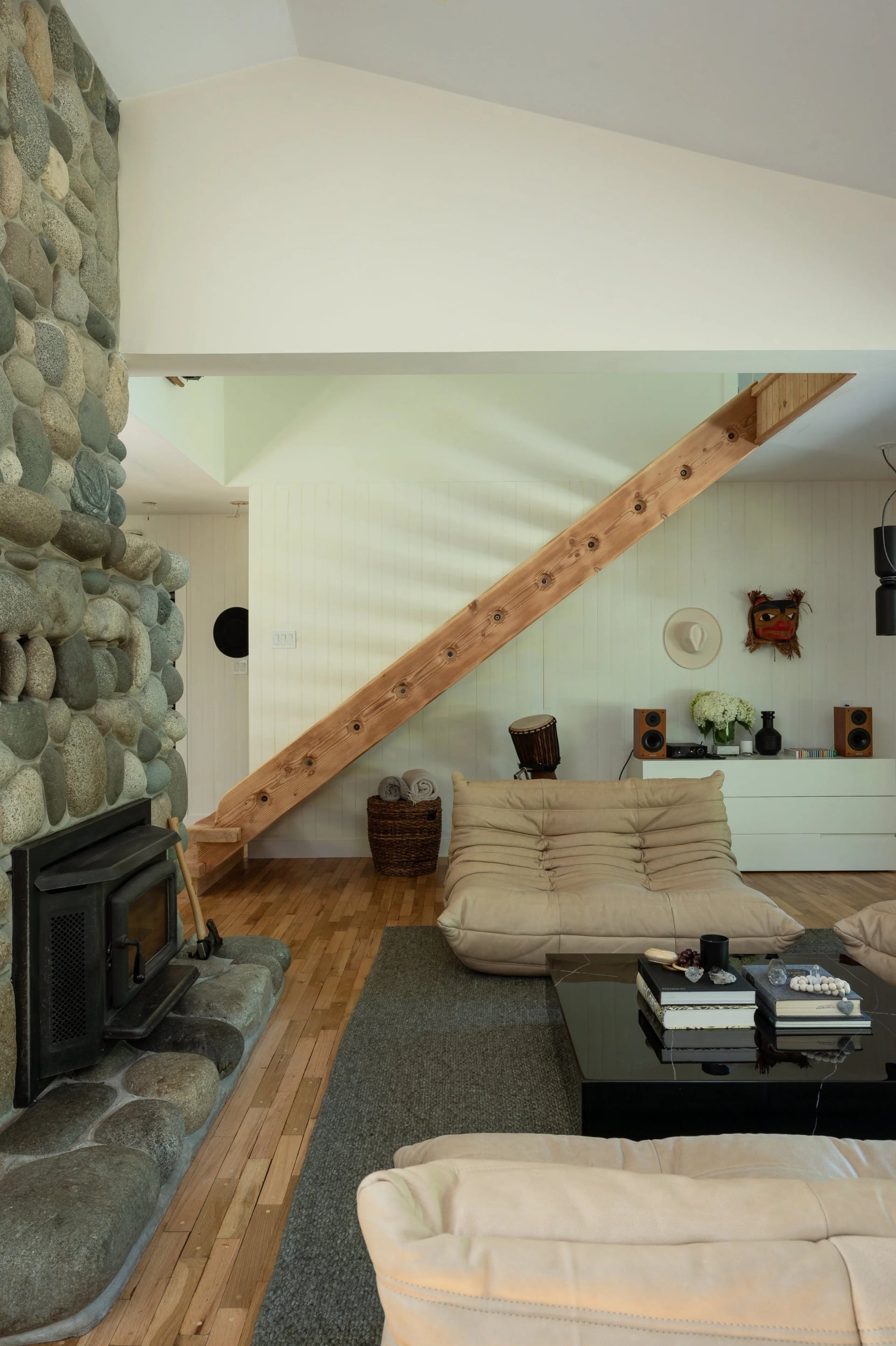 Floating wooden stairs beside the stone fireplace