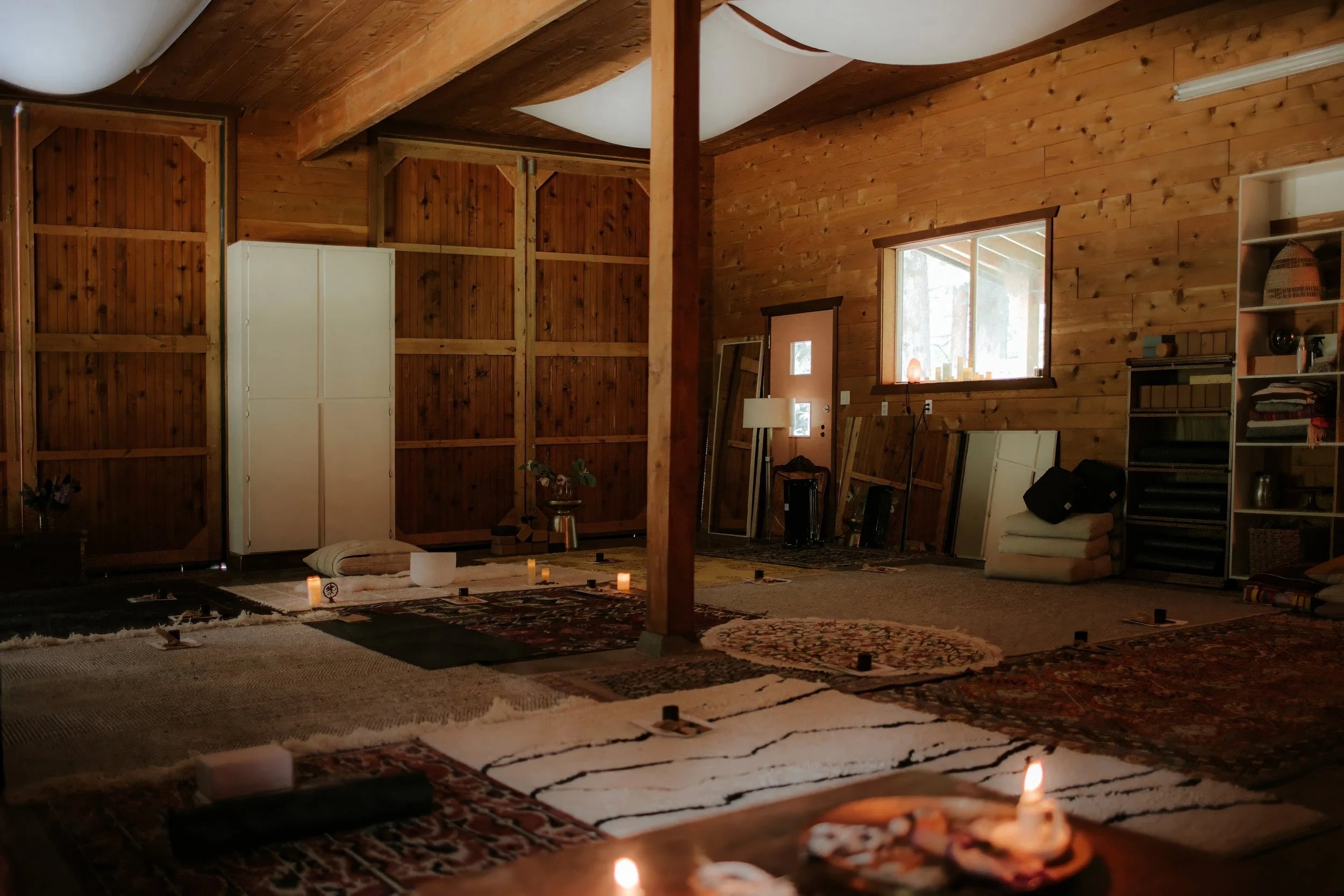 Mats, cushions and a candlelit table inside the cedar-walled barn
