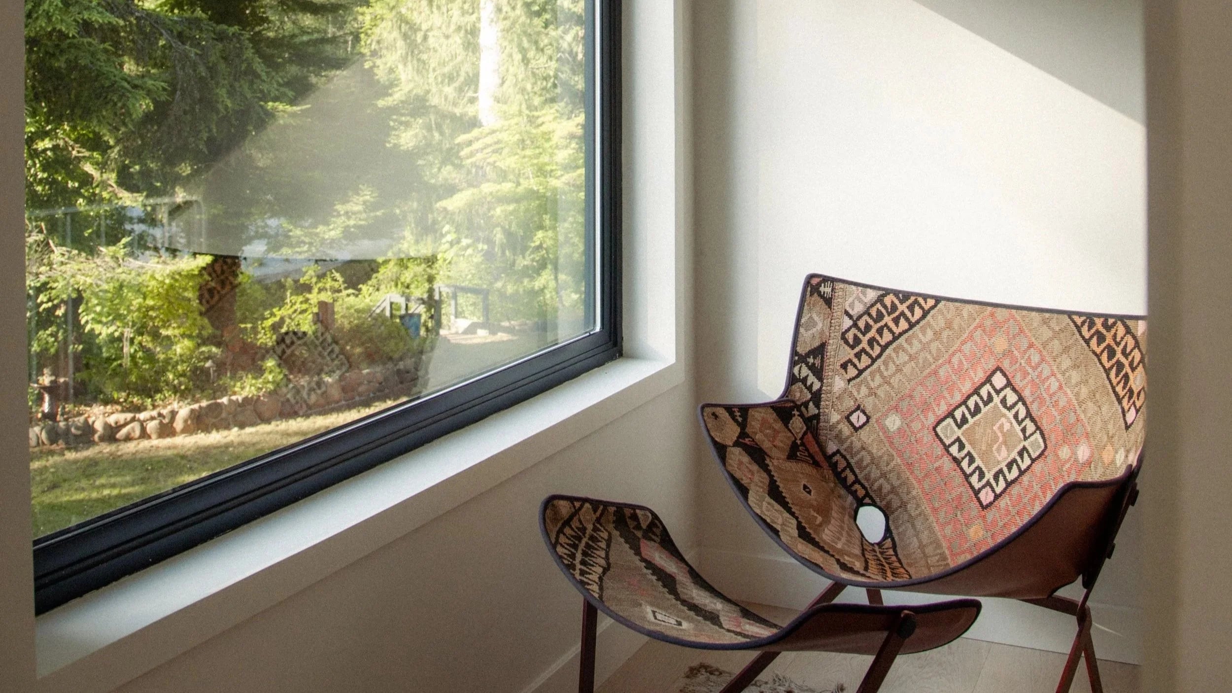 A leather chair with a woven cushion beside a big window