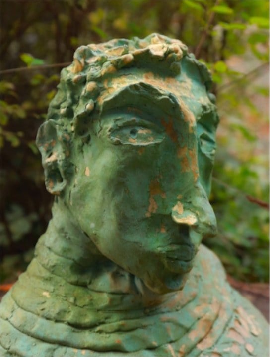 A green-glazed sculpted head in the garden