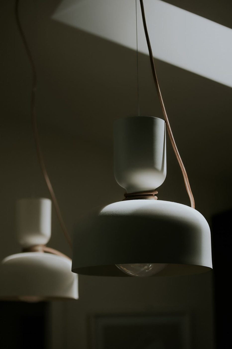 Two pale pendant lamps hanging in soft light